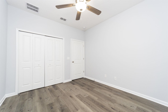 unfurnished bedroom featuring ceiling fan, wood-type flooring, and a closet