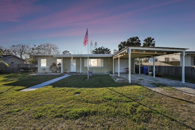 view of front of house with a carport and a lawn