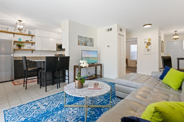 tiled living room with a chandelier