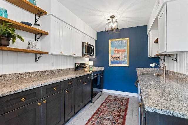 kitchen featuring stainless steel appliances, white cabinetry, sink, and decorative light fixtures