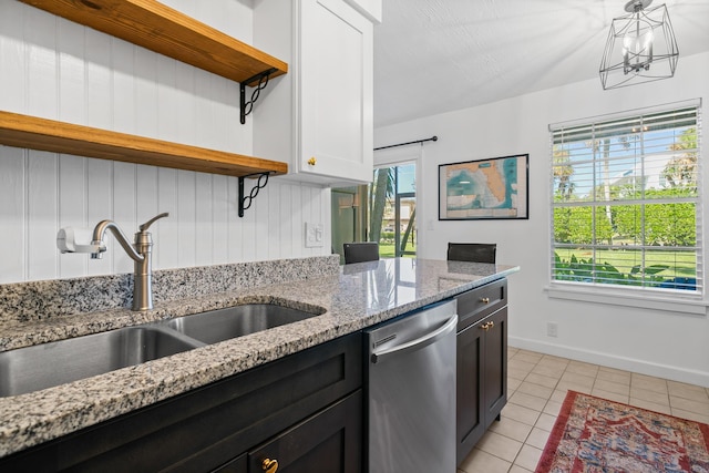 kitchen featuring sink, light tile patterned floors, light stone countertops, white cabinets, and stainless steel dishwasher