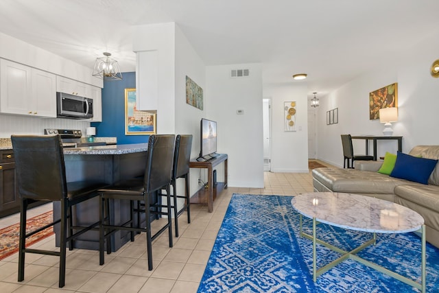 living room with a chandelier and light tile patterned floors