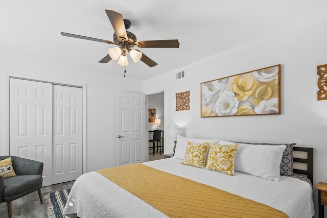 bedroom featuring hardwood / wood-style flooring, ceiling fan, and a closet