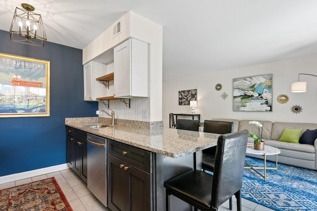 kitchen featuring sink, white cabinetry, light stone counters, decorative light fixtures, and dishwasher