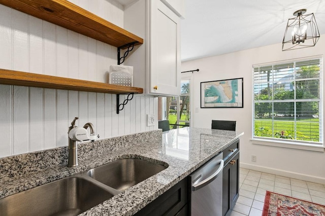 kitchen featuring sink, white cabinetry, hanging light fixtures, stainless steel dishwasher, and light stone countertops