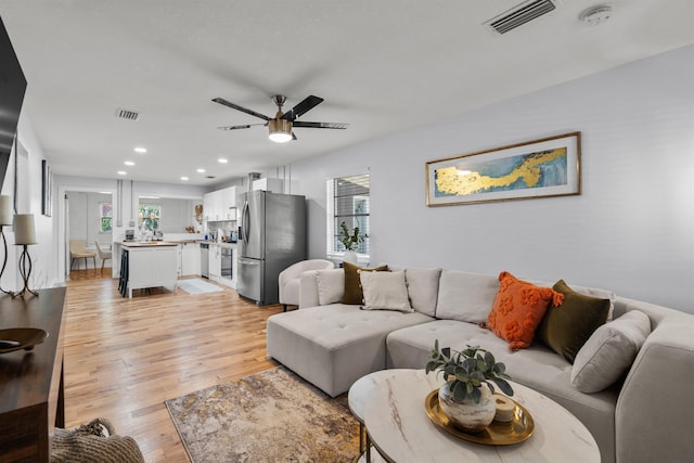 living area featuring recessed lighting, ceiling fan, visible vents, and light wood-type flooring