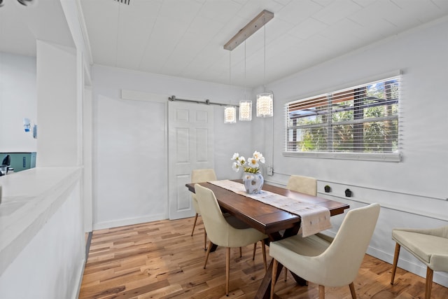 dining space with crown molding and light wood-type flooring