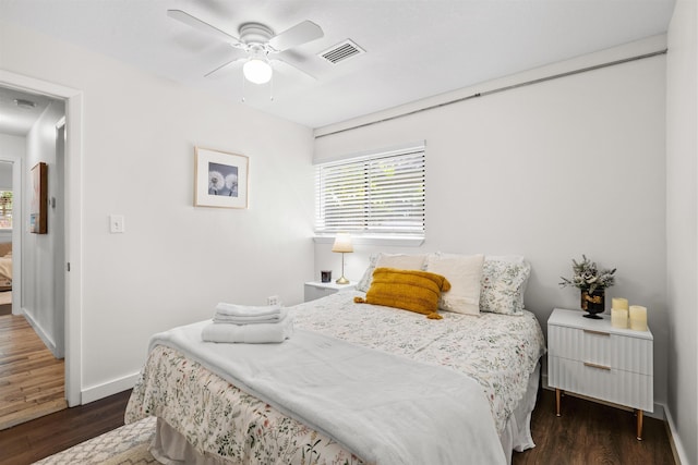 bedroom featuring baseboards, ceiling fan, dark wood finished floors, and visible vents