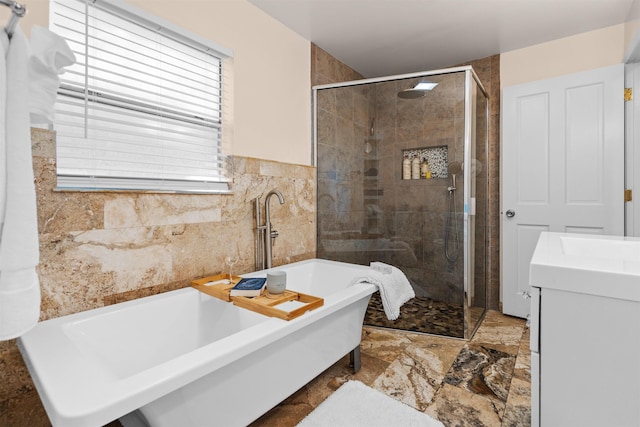 bathroom with tile walls, a soaking tub, and a stall shower