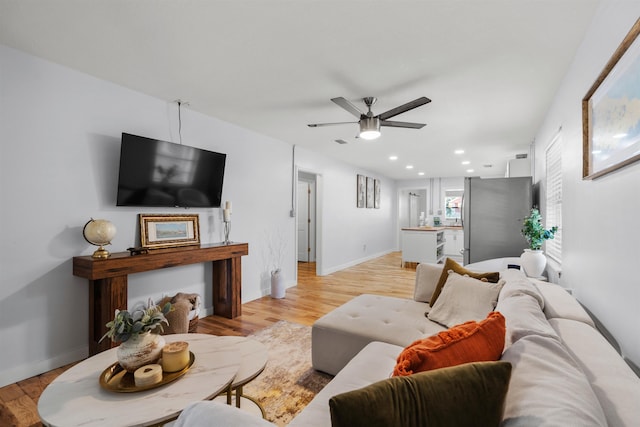 living area featuring recessed lighting, a ceiling fan, light wood finished floors, and baseboards