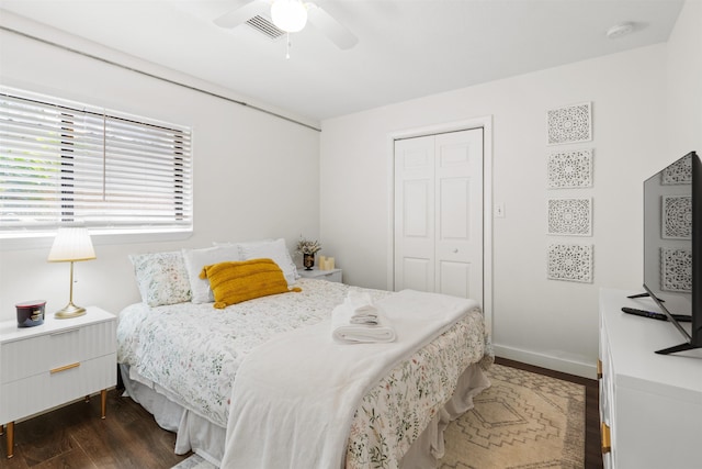 bedroom with a closet, visible vents, baseboards, dark wood-style floors, and a ceiling fan