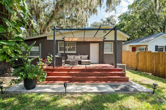 rear view of house with fence, central AC, an outdoor hangout area, stucco siding, and a deck