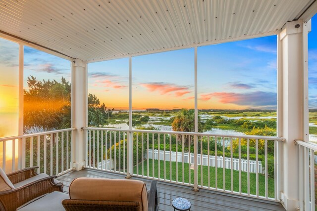 sunroom featuring plenty of natural light and a water view