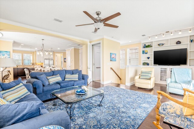 living room featuring hardwood / wood-style floors, ceiling fan with notable chandelier, a healthy amount of sunlight, and crown molding