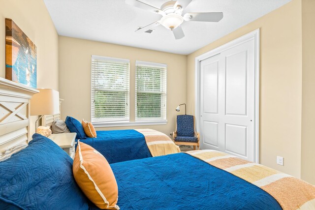 bedroom with ceiling fan and a closet