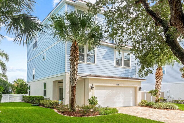 view of front of property with a garage and a front lawn