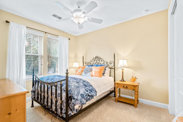 bedroom with carpet, ceiling fan, and multiple windows