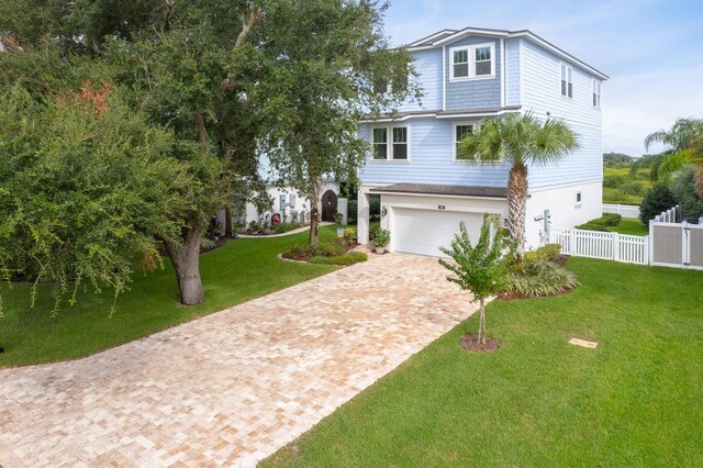 view of front of property with a garage and a front lawn