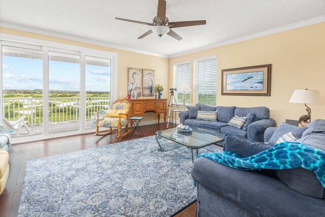 living room featuring a wealth of natural light, hardwood / wood-style flooring, ceiling fan, and crown molding