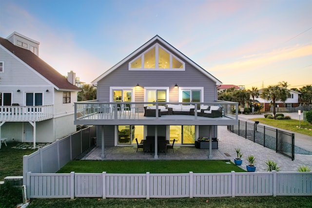 back house at dusk with a yard and a patio