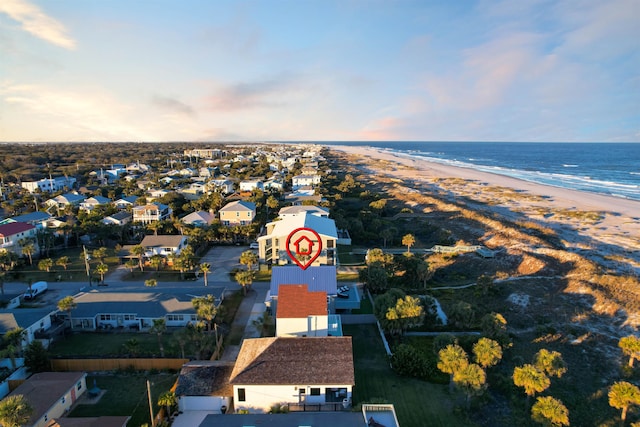 aerial view at dusk with a water view and a view of the beach