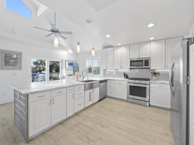 kitchen featuring white cabinets, kitchen peninsula, appliances with stainless steel finishes, and sink