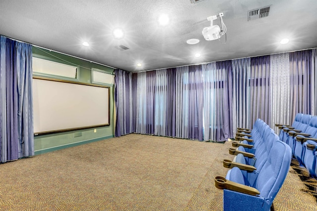 home theater with carpet, visible vents, and a textured ceiling