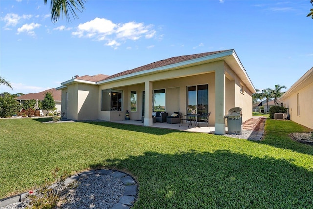 rear view of property with a patio area, a yard, and stucco siding