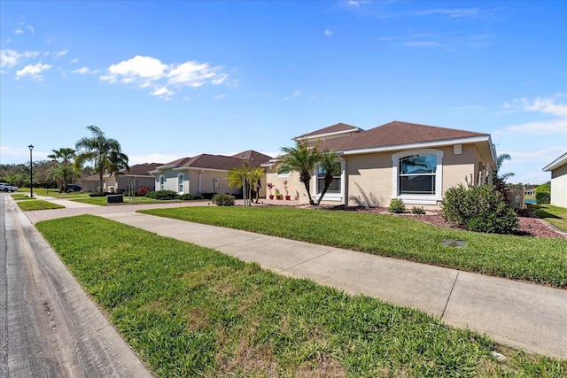 view of front facade with a front yard and stucco siding