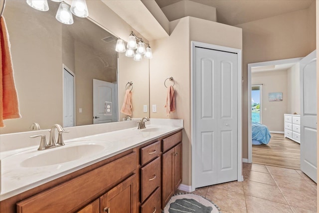 bathroom with double vanity, a closet, tile patterned flooring, and a sink