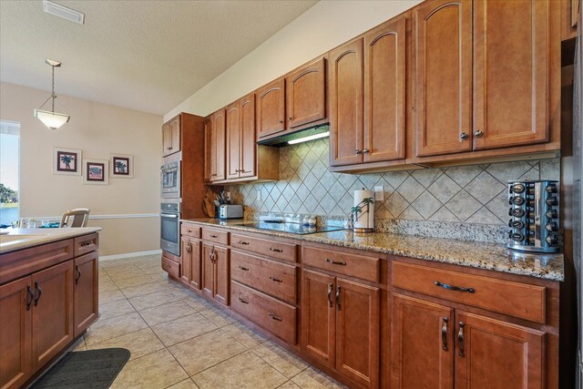 kitchen featuring light tile patterned floors, visible vents, hanging light fixtures, under cabinet range hood, and black electric cooktop