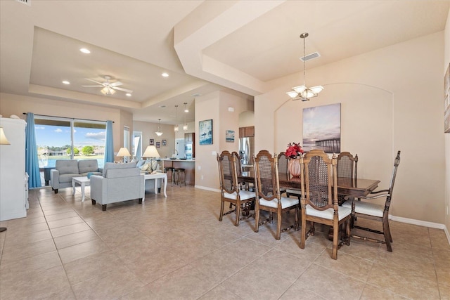 dining space with a tray ceiling, recessed lighting, visible vents, baseboards, and ceiling fan with notable chandelier