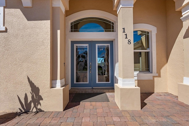 doorway to property featuring french doors and stucco siding