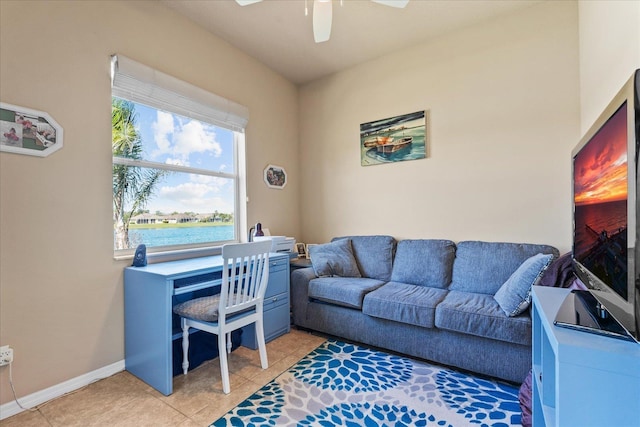 home office featuring a ceiling fan, a water view, baseboards, and light tile patterned floors