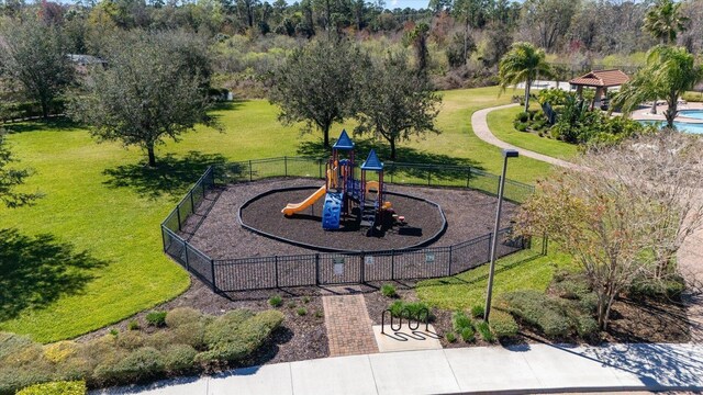 exterior space with playground community, a yard, and fence