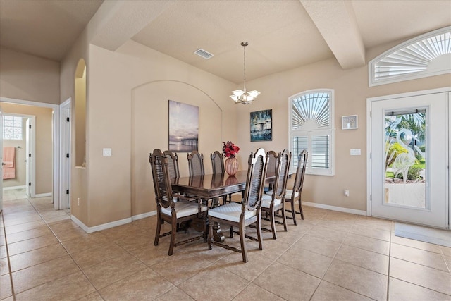 dining area featuring light tile patterned floors, baseboards, visible vents, and a notable chandelier