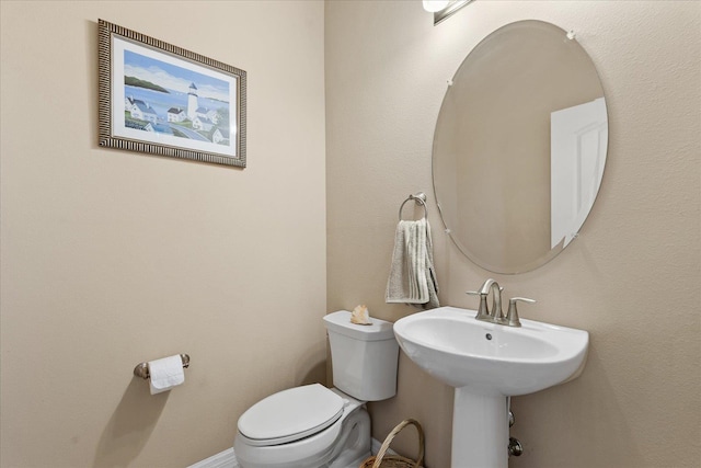 bathroom with baseboards and toilet