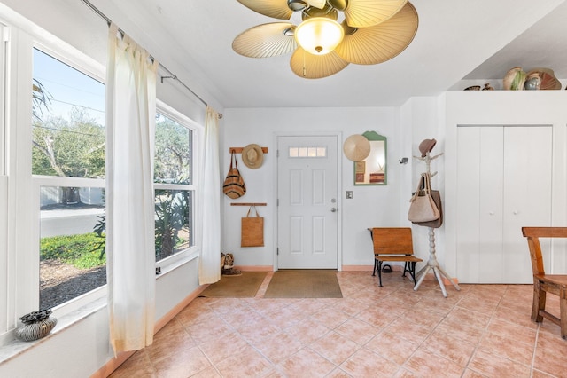 entryway with light tile patterned floors and ceiling fan