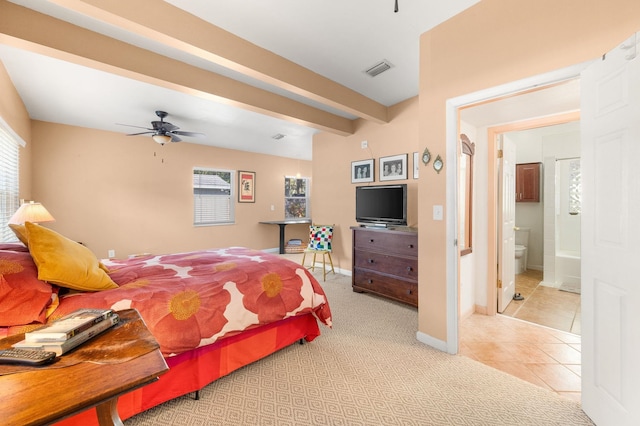 bedroom featuring ceiling fan, ensuite bath, multiple windows, and light tile patterned floors