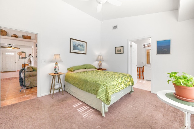 carpeted bedroom with vaulted ceiling, ceiling fan, and ensuite bathroom