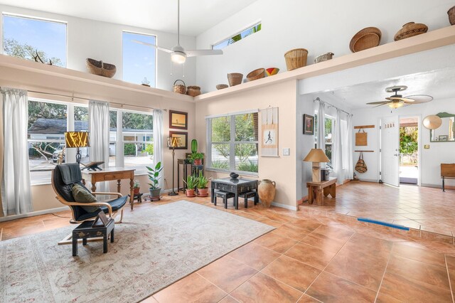 living area featuring high vaulted ceiling, ceiling fan, and light tile patterned flooring