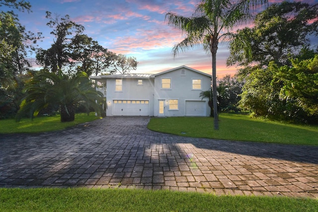 view of front of home with a garage and a yard