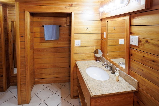 bathroom with tile patterned floors, wooden walls, and vanity
