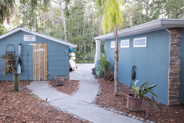 exterior space featuring an outdoor structure and stucco siding
