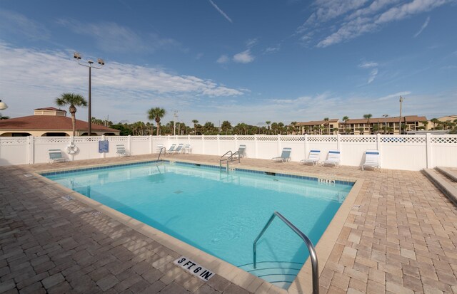 community pool featuring fence and a patio area