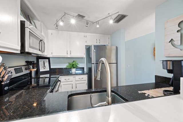 kitchen featuring visible vents, appliances with stainless steel finishes, white cabinetry, and dark stone counters