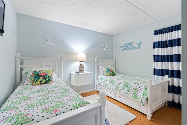 bedroom with light wood-style flooring and a textured ceiling