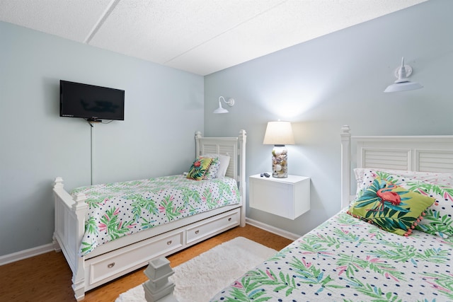 bedroom featuring wood finished floors and baseboards