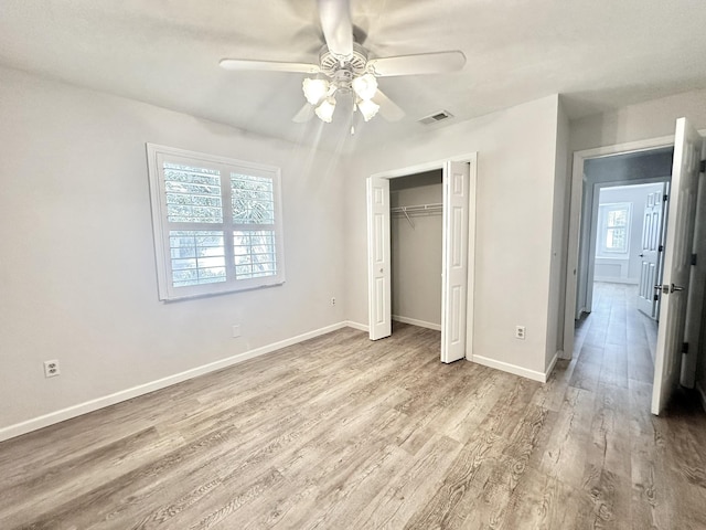 unfurnished bedroom with visible vents, wood finished floors, a closet, baseboards, and ceiling fan