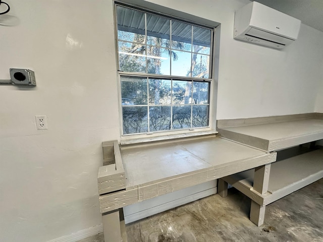 mudroom with unfinished concrete flooring and a wall mounted AC